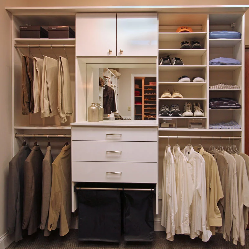 walk in closet with white custom cabinetry and mens clothing