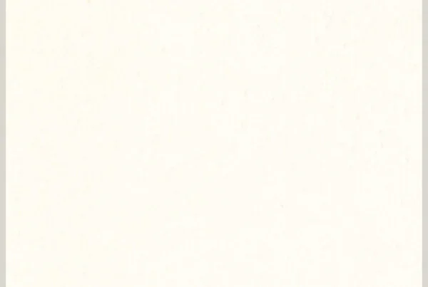 A blank off-white or cream-colored sheet of paper with a subtle texture and faint specks.