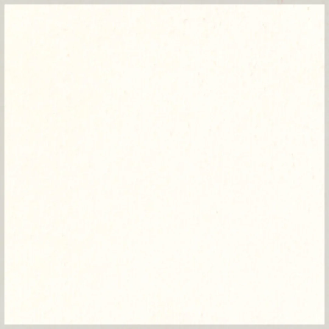 A blank off-white or cream-colored sheet of paper with a subtle texture and faint specks.